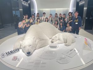 ヤマハイノベーションロードの白熊の親子のオブジェと記念写真を撮る水戸先生とゼミ生たち。