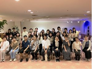 足立ゼミ集合写真。中央前列に足立先生、31名の学生が3列に並んで、笑顔でピースなどしている。