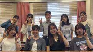 水戸ゼミ3年生の集合写真。教員1名と学生8名が教室で笑顔でピースサインをしている。
