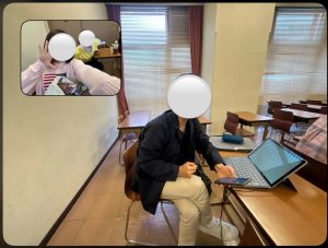 教室で撮られたビーリアルと思われる写真。タブレットの前に座る1人と、左上の小窓には2人がピースしている様子。顔は白丸で隠されている。