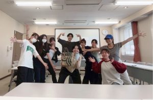 杉岡ゼミ集合写真3。中央の杉岡先生は、スタバの紙袋と水色のマグカップを持っている。その周りを8人のゼミ生が囲んで笑顔でこちらを向いている。