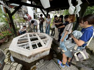 8角形の井戸の周りに集まるゼミ生たちの写真